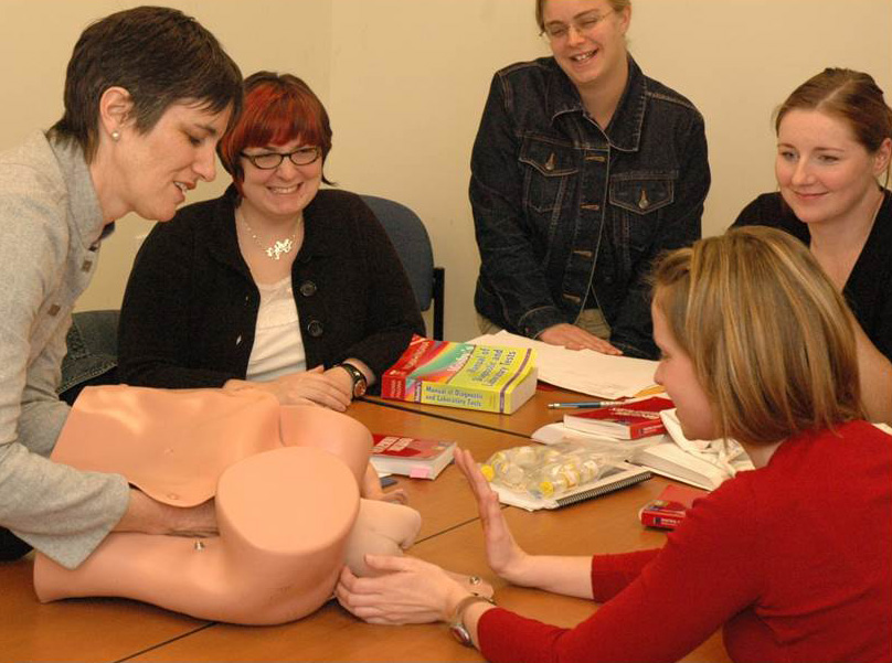 5 people participating in a midwife classroom demonstration