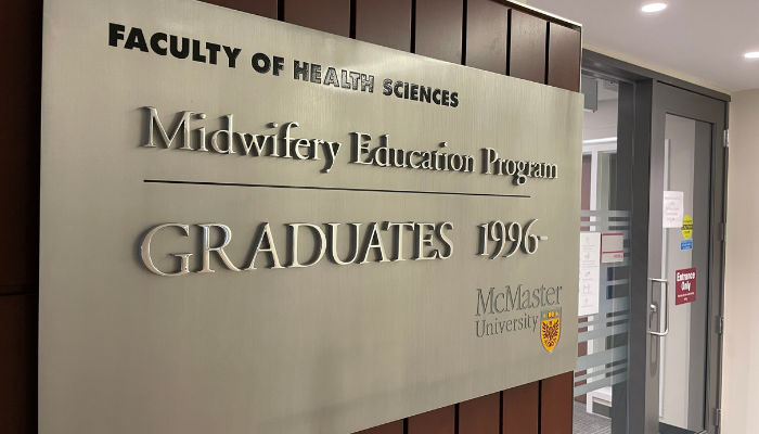 Large sign for the faculty of health sciences displaying the words Midwifery Education Program GRADUATES 1996